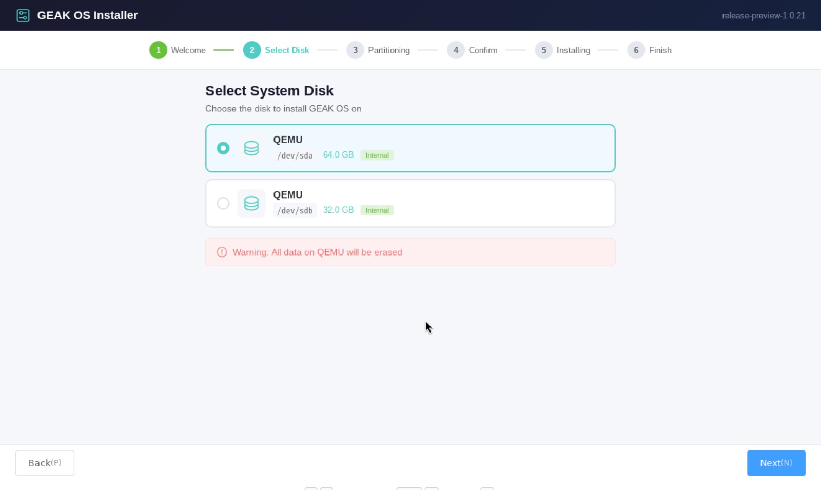 GEAK OS installer Select System Disk screen listing a 64 GB and a 32 GB QEMU disk